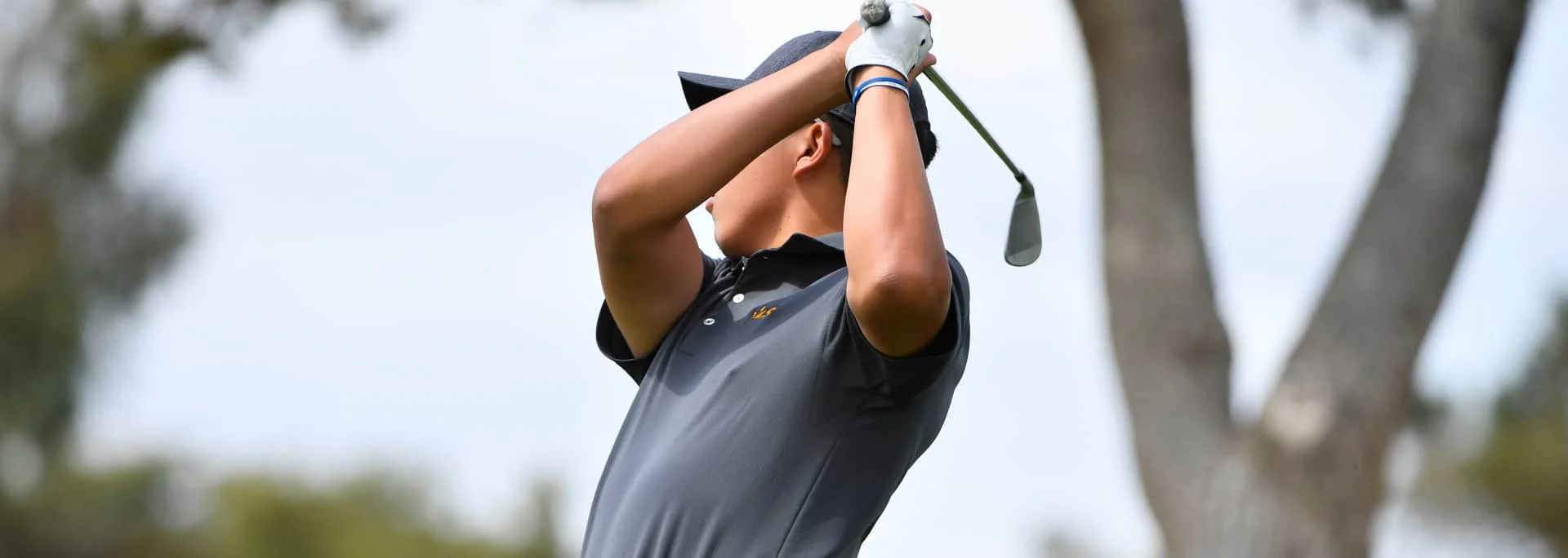 A student golf player after taking a shot.